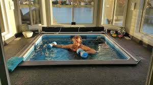 Woman performing aquatic exercises in her plunge pool.