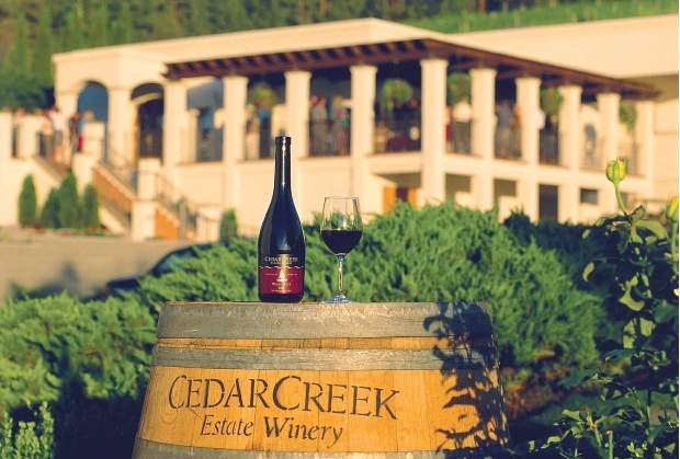A wine bottle and filled wine glass at Cedar Creek Estate Winery.
