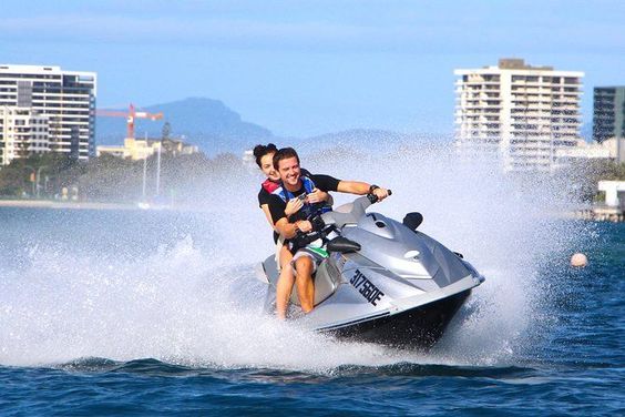 Couple riding a jet ski off the coast of South Stradbroke Island.
