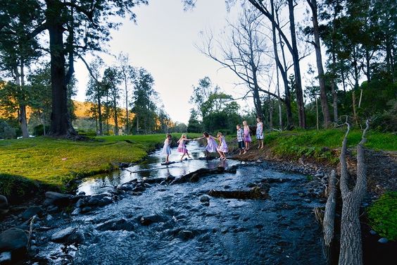 Children crossing a small river at O'Reilly's Canungra Valley.