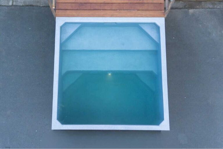 Top view of the Plungie Quad, a 2.2m x 2.2m square precast concrete plunge pool filled with water, positioned next to a timber deck.