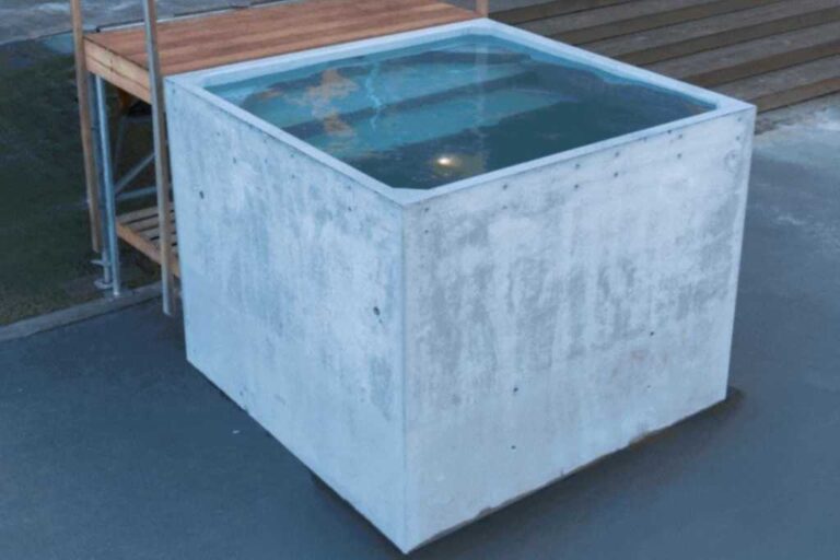Plungie Quad, a compact 2.2m x 2.2m square precast concrete plunge pool filled with water, installed beside a timber deck.