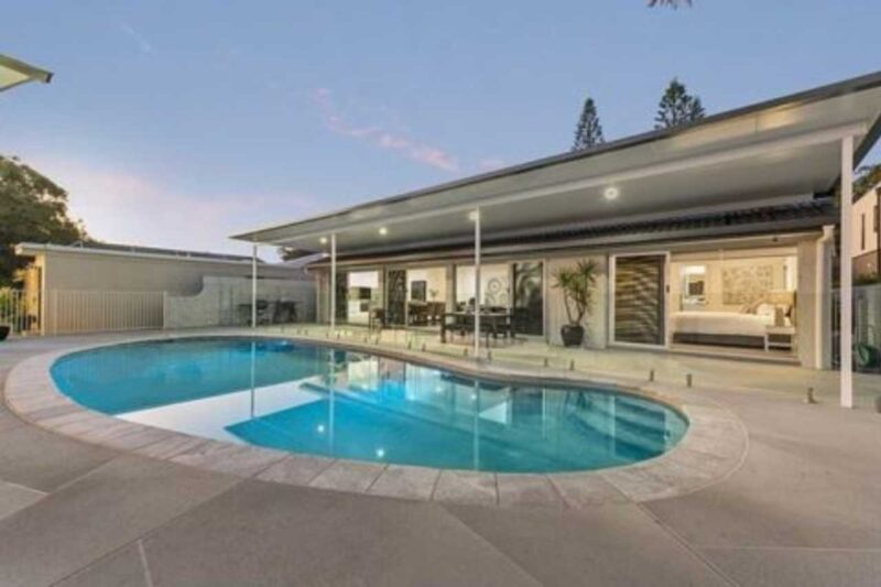 Residential backyard after pool renovation with modern concrete surface, new coping, glass fencing, and updated outdoor living area in a Gold Coast home.