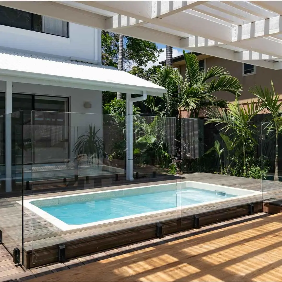 Modern inground plunge pool with glass fencing and timber deck in Carrara Gold Coast